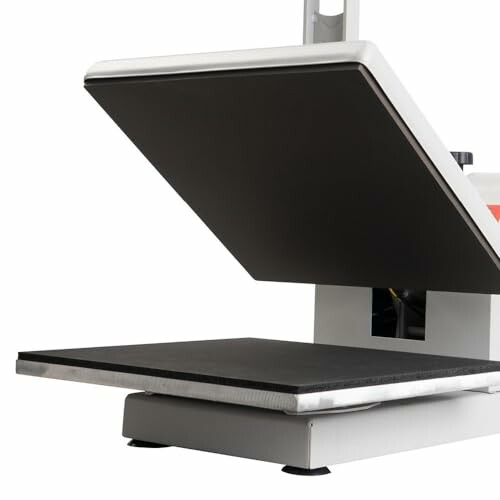 Open heat press machine with a black pressing surface